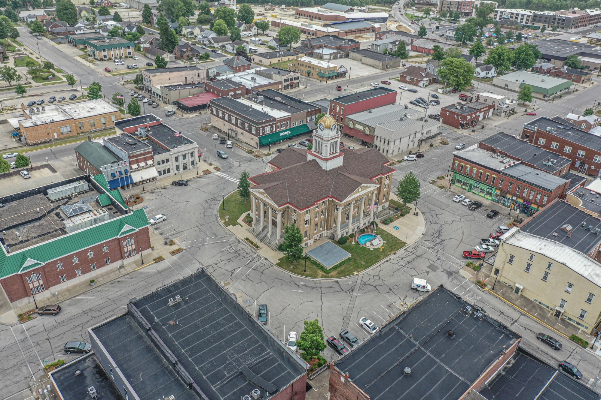 Aerial view of the Dubois County Courthouse in Jasper, Indiana, centered in a town square and surrounded by historic storefronts and city streets.